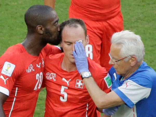 Switzerland's Johan Djourou, left, kisses his injured teammate