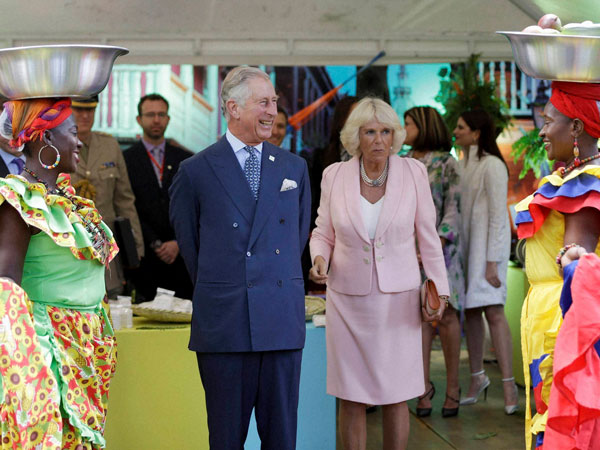 Women dressed as Palenqueras smile towards Britain's Prince Charles