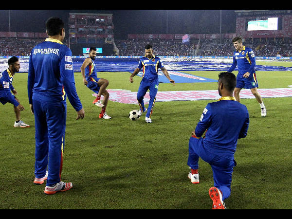 RCB captain Virat Kohli and his team-mates play football during a rain break at IPL 2015