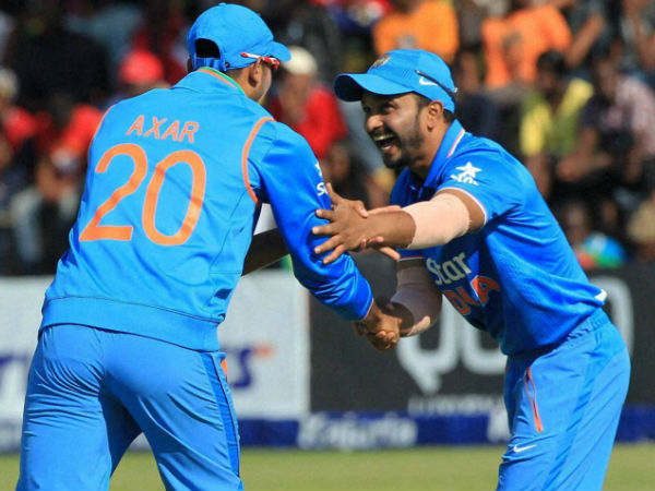 Axar and Jadhav celebrate a wicket