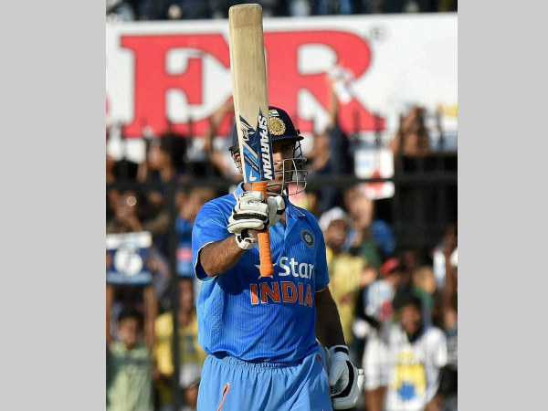 Dhoni raises his bat after completing half century