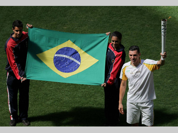 File photo: Brazil's former soccer player Lucio da Silva Ferreira holds the Olympic torch by the Brazilian flag during the torch relay in Brasilia in May. File photo: Brazil's former soccer player Lucio da Silva Ferreira holds the Olympic torch by the Brazilian flag during the torch relay in Brasilia in May.