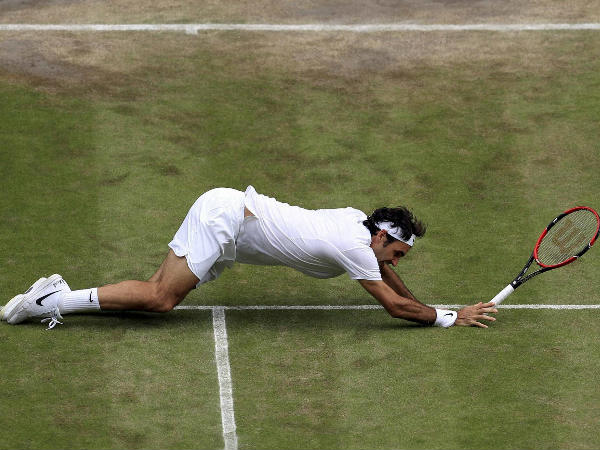 Federer falls during his match against Raonic