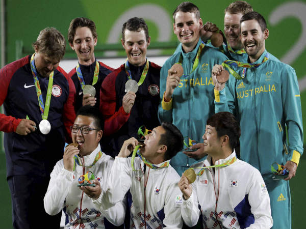 Gold medalists from South Korea (bottom) celebrate their triumph in men's archery