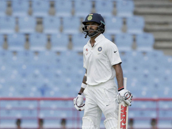Shikhar Dhawan looks at the board as he leaves the field after he was caught by West Indies' wicketkeeper Shane Dorwich on day one of their third cricket Test match.