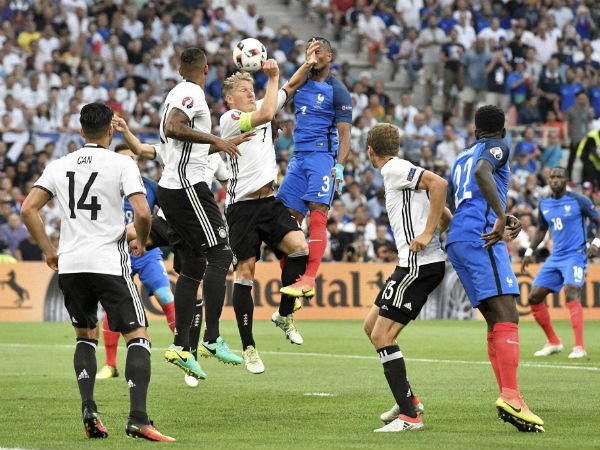  Germany's Bastian Schweinsteiger, center left, jumps for the ball with France's Patrice Evra during the Euro 2016 semifinal soccer match between Germany and France.