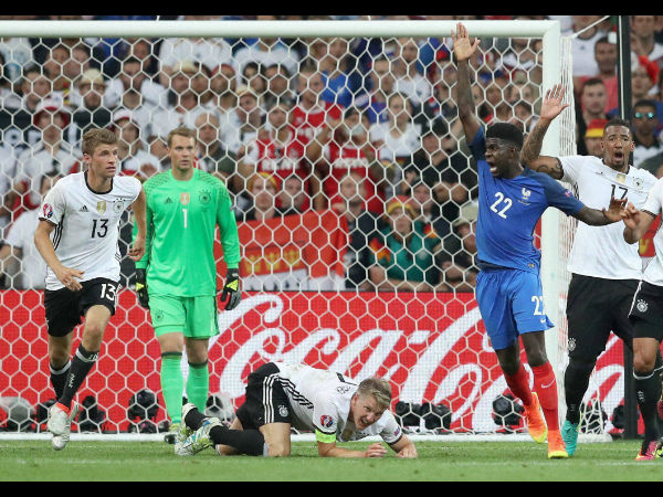 Germany's Bastian Schweinsteiger, bottom, lies on the pitch after conceding a penalty for hand ball during the Euro 2016 semifinal soccer match between Germany and France.