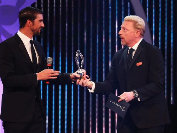 Michael Phelps (left) collects his award from Boris Becker