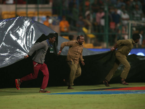 Ground staff bring the covers on