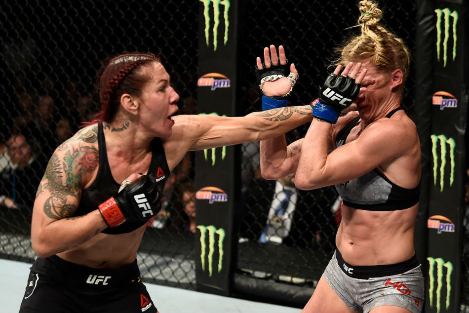 Cris Cyborg (left) punches Holly Holm during her title defense at UFC 219 (Image Courtesy: UFC twitter) Cris Cyborg (left) punches Holly Holm during her title defense at UFC 219 (Image Courtesy: UFC twitter)