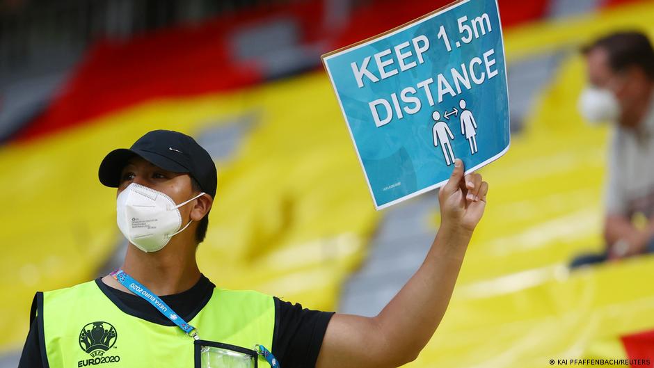 Worth a try: A steward in Munich holds up a sign reminding fans to keep their distance Worth a try: A steward in Munich holds up a sign reminding fans to keep their distance