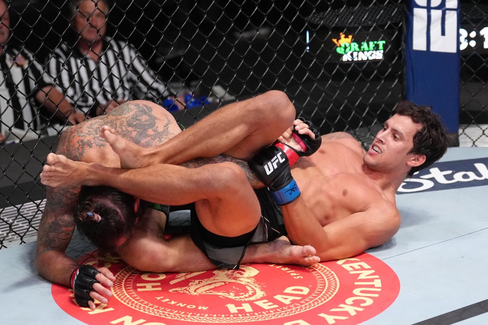 (R-L) Claudio Puelles works for a submission against Clay Guida. (Photo by Jeff Bottari/Zuffa LLC)