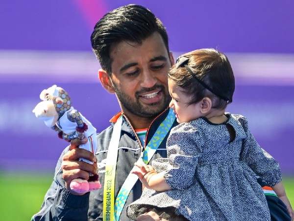 Hockey team skipper Manpreet Singh poses with his medal with his daughter