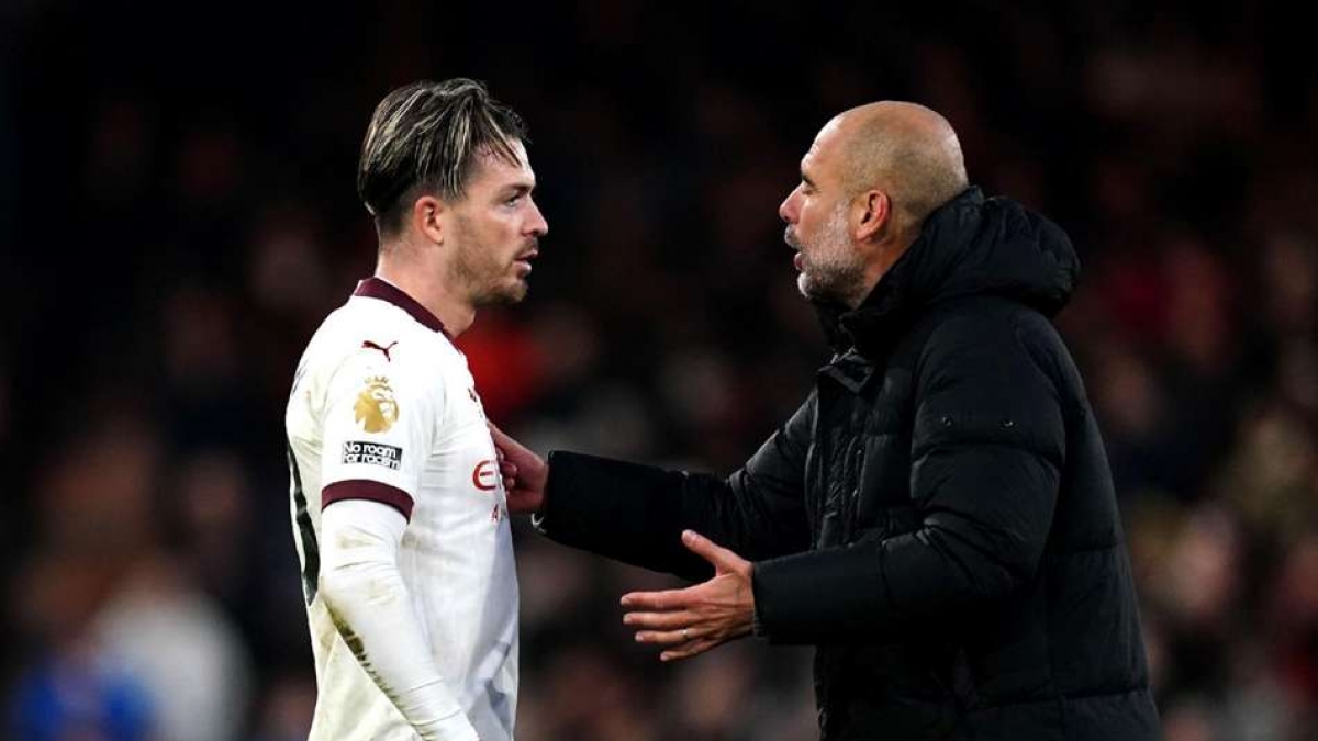 Jack Grealish left and Pep Guardiola right talk on the pitch