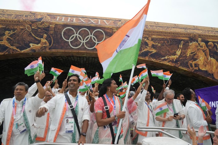 Indian athletes wave their national flags from a boat on the Seine River in Paris, France, during the opening ceremony of the 2024 Summer Olympics, Friday, July 26, 2024.