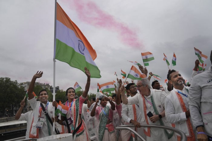 Indian athletes wave their national flags from a boat on the Seine River in Paris, France, during the opening ceremony of the 2024 Summer Olympics, Friday, July 26, 2024.