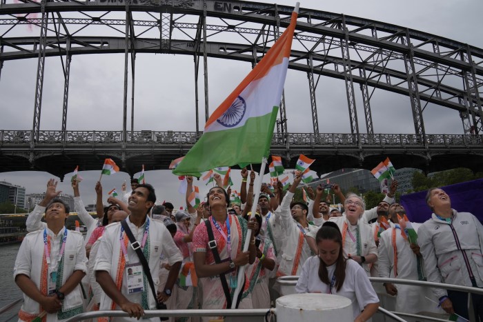 Indian athletes wave their national flags from a boat on the Seine River in Paris, France, during the opening ceremony of the 2024 Summer Olympics, Friday, July 26, 2024